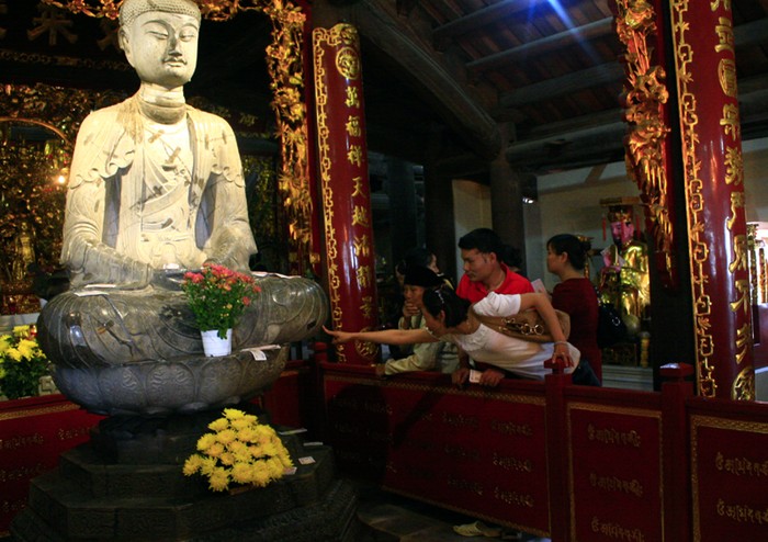 Cài tiền lên tượng Phật chưa đủ, nhiều người còn kiểm chứng xem tượng Phật là thật hay giả khiến chân tượng nhẵn thín